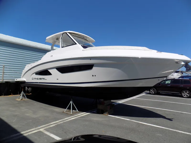 Slide: The Image of 2019 Regal 33 SAV boat on display in a parking lot under clear blue sky. - 2