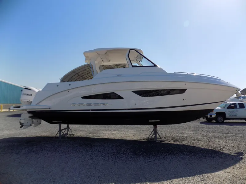 Slide: The Image of 2019 Regal 33 SAV boat on display, white hull, parked on gravel lot. - 5