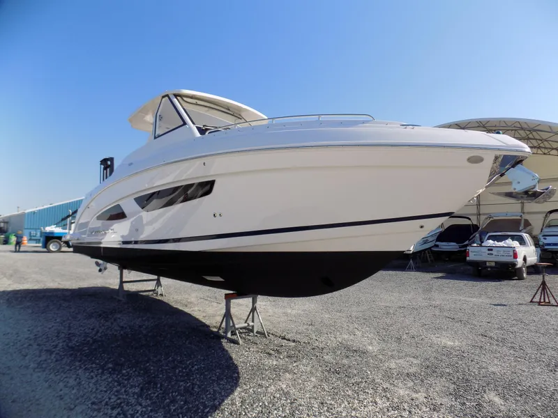 Slide: The Image of 2019 Regal 33 SAV boat on stands in a gravel lot under clear blue sky. - 6