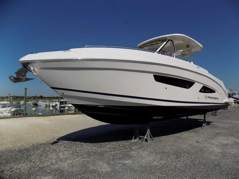 Slide: The Image of 2019 Regal 33 SAV boat on display at a marina under clear blue skies. - 7