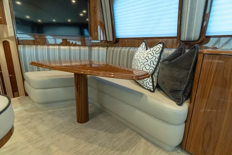 Slide: The Image of Luxurious interior of 2025 Viking 54 yacht with plush seating and elegant wooden table. - 13