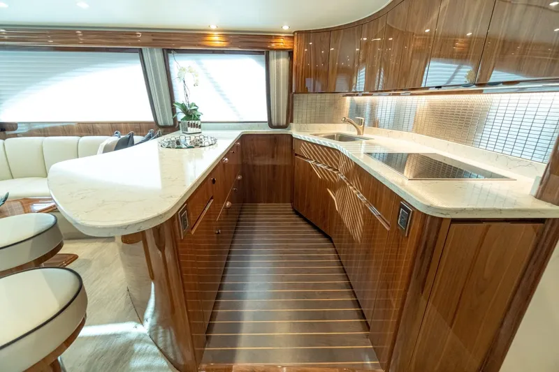 Slide: The Image of Luxurious kitchen interior of 2025 Viking 54 yacht with modern wood cabinetry and marble countertops. - 14