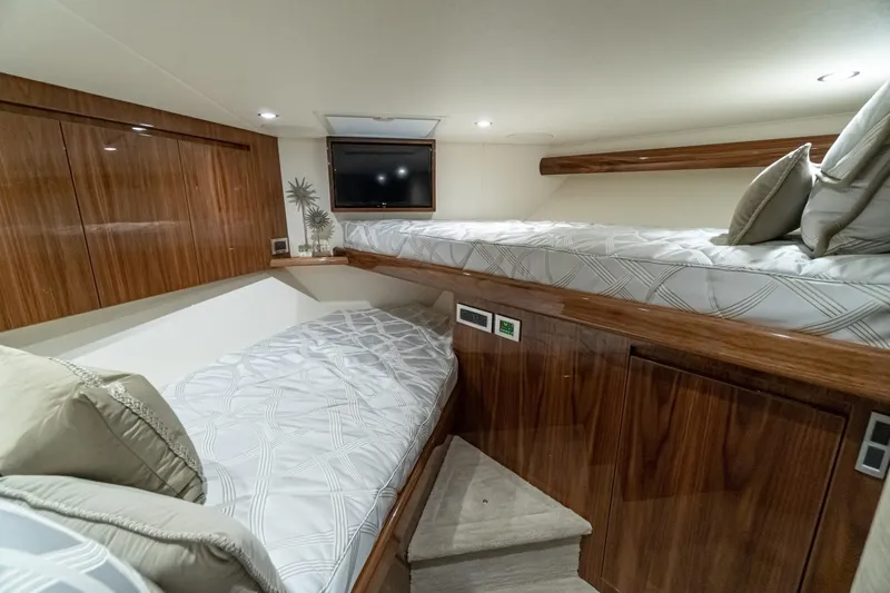 Slide: The Image of Luxurious cabin interior of 2025 Viking 54 yacht with twin beds and wooden finish. - 16
