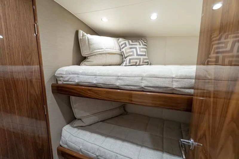 Slide: The Image of 2025 Viking 54 yacht interior with cozy bunk beds. - 17