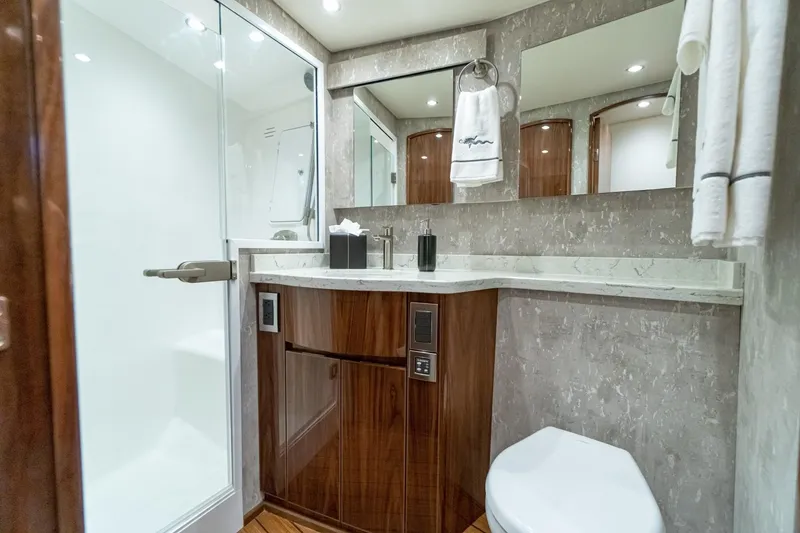 Slide: The Image of Modern bathroom in 2025 Viking 54 yacht with glass shower, wooden cabinetry, and marble countertop. - 18