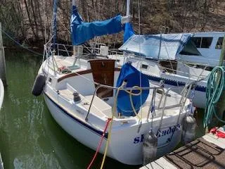 Slide: The Image of 1988 Newport 27 sailboat docked, featuring blue sail cover and white hull. - 0
