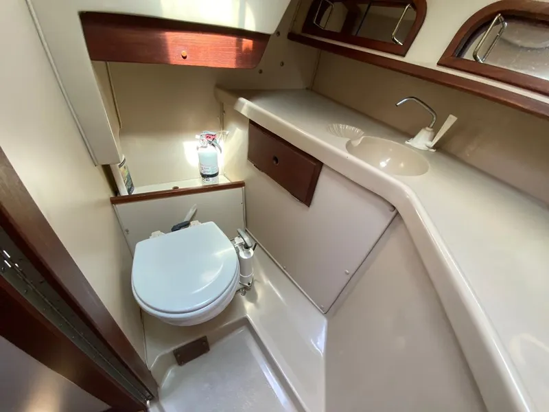 Slide: The Image of Compact bathroom in a 1988 Newport 27 yacht, featuring a toilet and sink. - 6