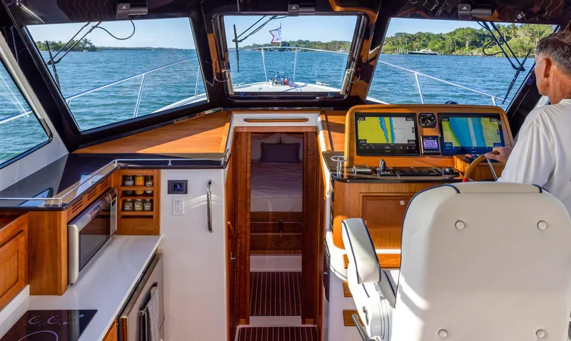 Slide: The Image of Interior helm of 2025 Back Cove 372 yacht with navigation screens and wood finishes. - 15
