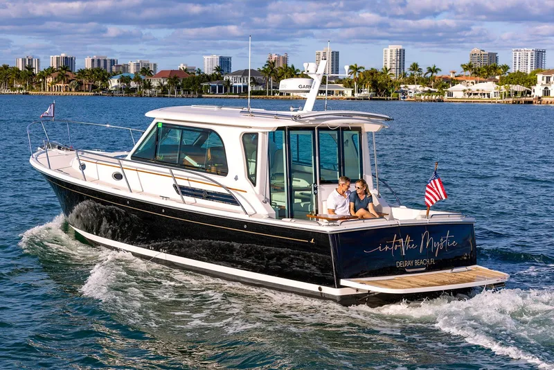 Slide: The Image of 2025 Back Cove 372 cruising near coastal city skyline. - 4