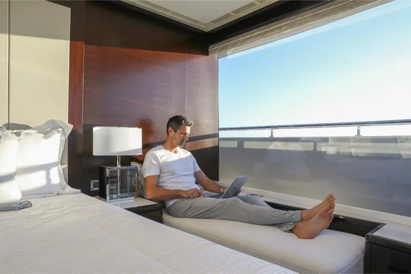 Slide: The Image of Man relaxing with laptop in luxurious Ocean Alexander 37L yacht bedroom, 2023 model. - 18