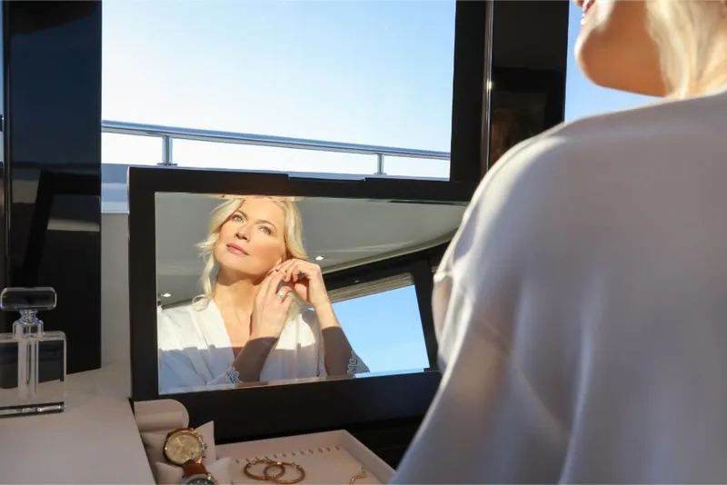 Slide: The Image of Woman putting on earrings in front of mirror on Ocean Alexander 37L yacht, 2023 model. - 19