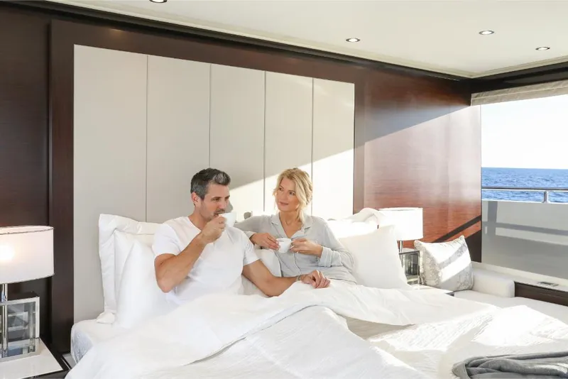 Slide: The Image of Couple relaxing in the luxurious bedroom of a 2023 Ocean Alexander 37L yacht. - 22