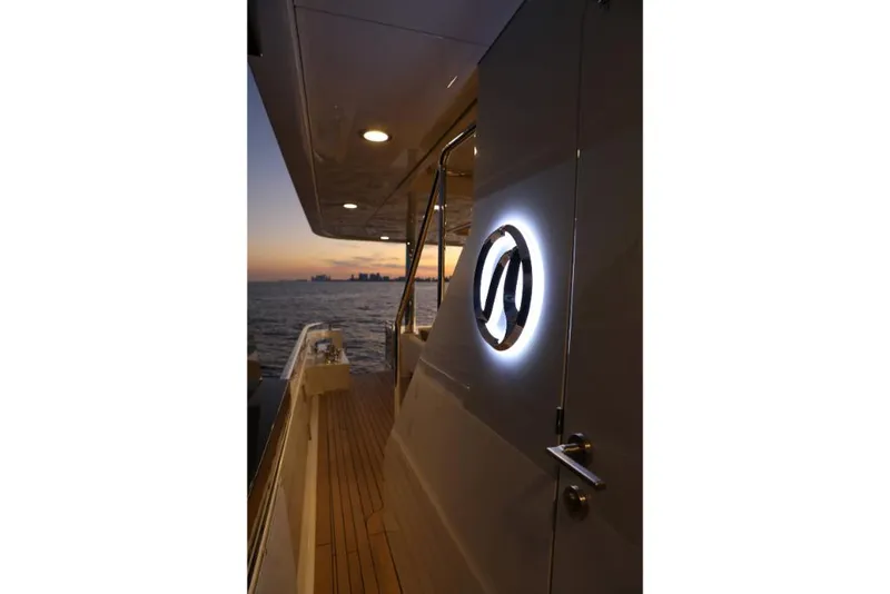 Slide: The Image of Ocean Alexander 37L 2023 yacht deck at sunset, illuminated logo, luxury maritime design. - 47