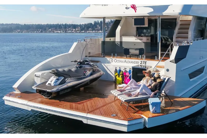 Slide: The Image of Luxury 2023 Ocean Alexander 27E yacht with jet ski and sunbathing area on the water. - 6