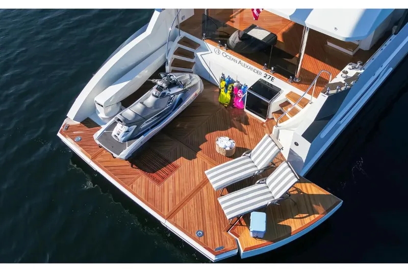 Slide: The Image of Luxury 2023 Ocean Alexander 27E yacht with teak deck, jet ski, and lounge chairs. - 8