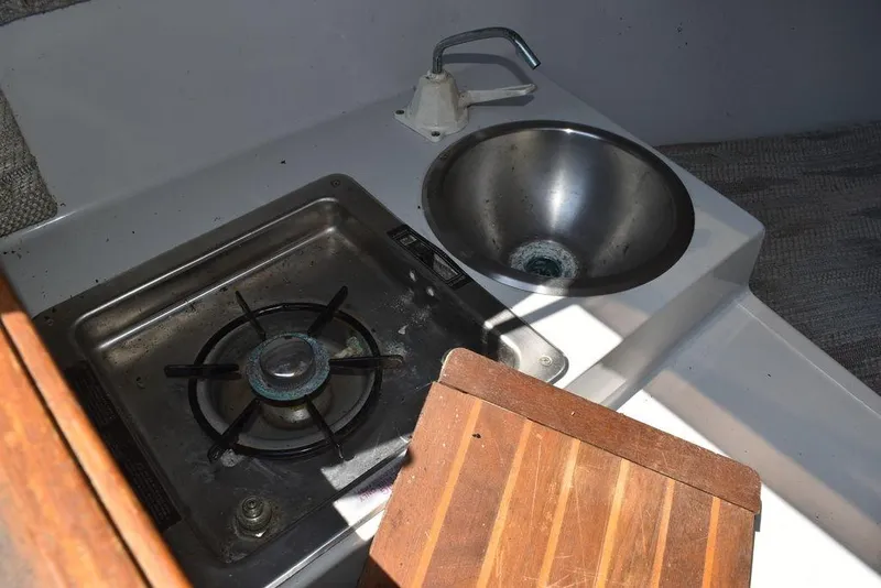 Slide: The Image of Compact kitchen area in a 1991 Sea Sprite 225 boat with stove and sink. - 14