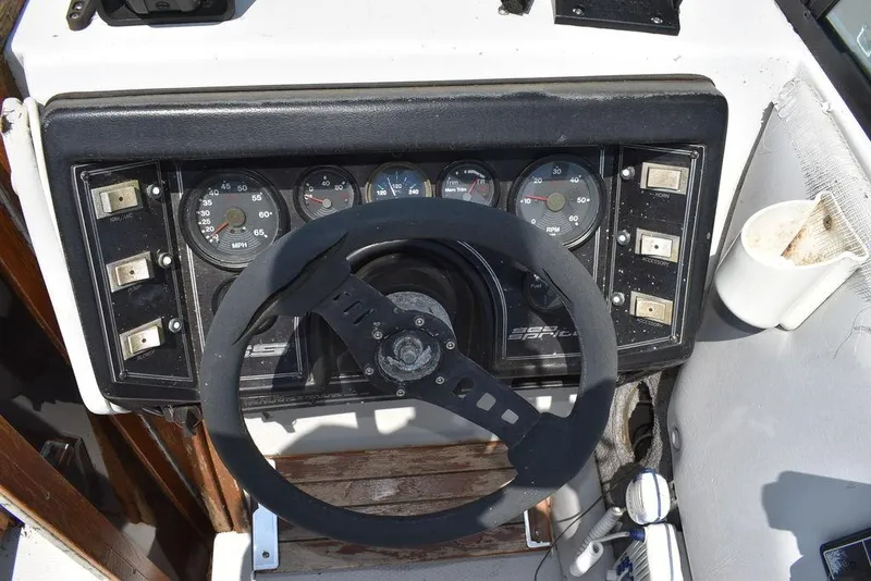 Slide: The Image of 1991 Sea Sprite 225 boat dashboard with steering wheel and instrument panel. - 27