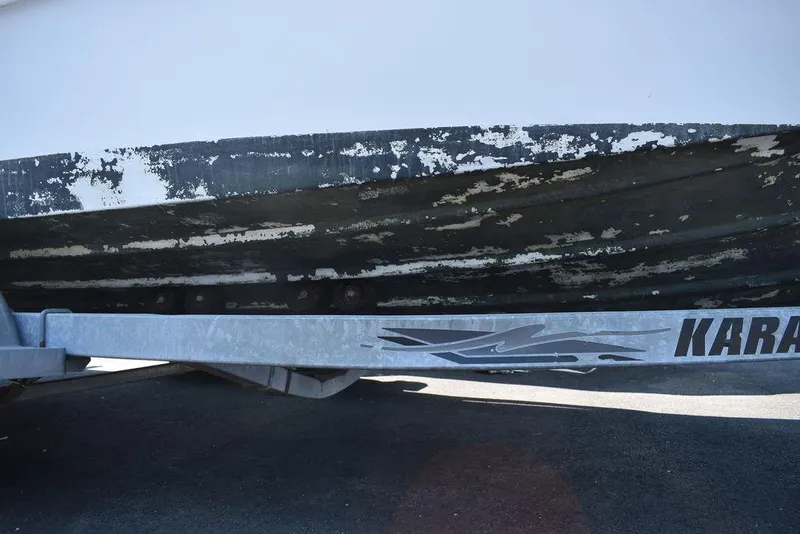 Slide: The Image of 1991 Sea Sprite 225 boat hull on trailer with peeling paint. - 31