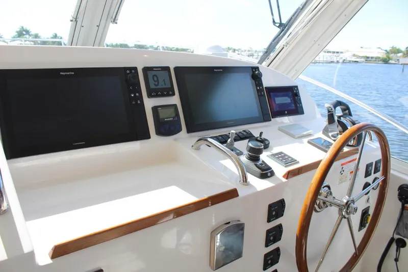 Slide: The Image of 2023 MJM 53z boat helm with advanced navigation systems and wooden steering wheel. - 15