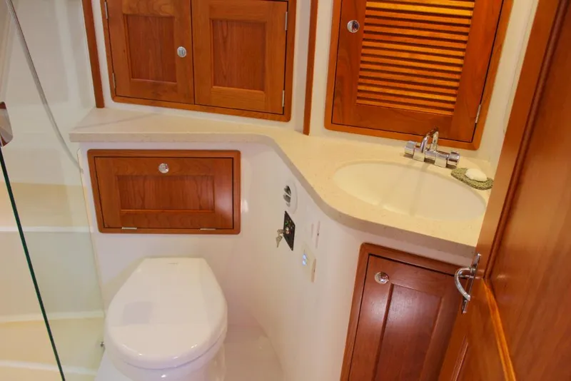 Slide: The Image of 2023 MJM 53z yacht bathroom with wooden cabinets, sink, and toilet. - 22