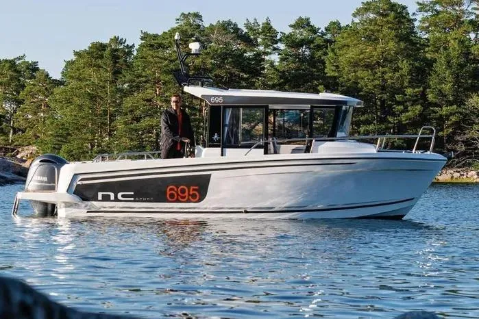 Slide: The Image of 2026 Jeanneau NC Sport 695 Series 2 boat on water, surrounded by trees. - 1