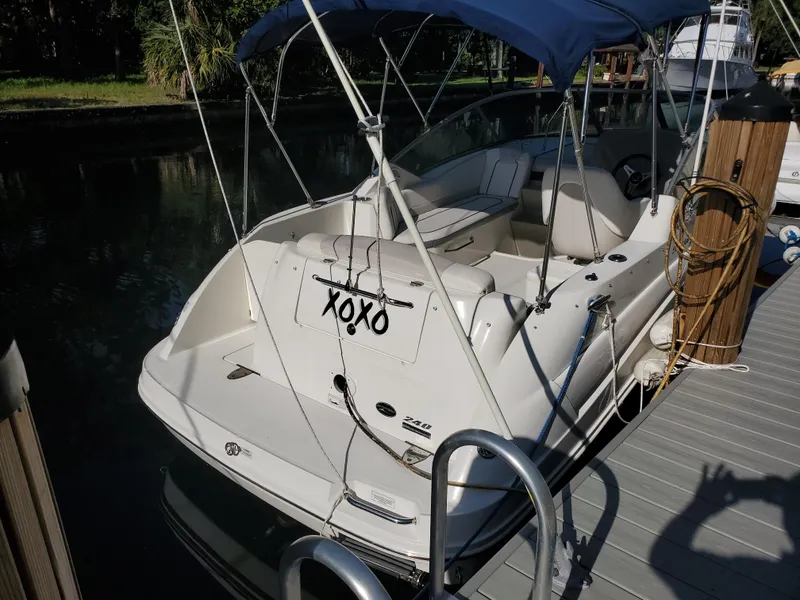 Slide: The Image of 2010 Sea Ray 240 Sundancer docked with blue canopy. - 2