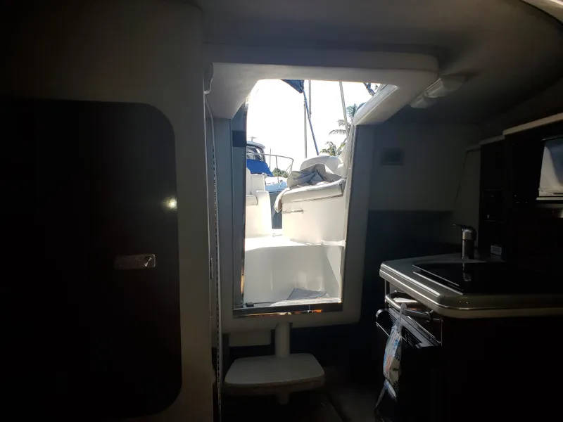 Slide: The Image of Interior view of 2010 Sea Ray 240 Sundancer cabin with open door to deck. - 8