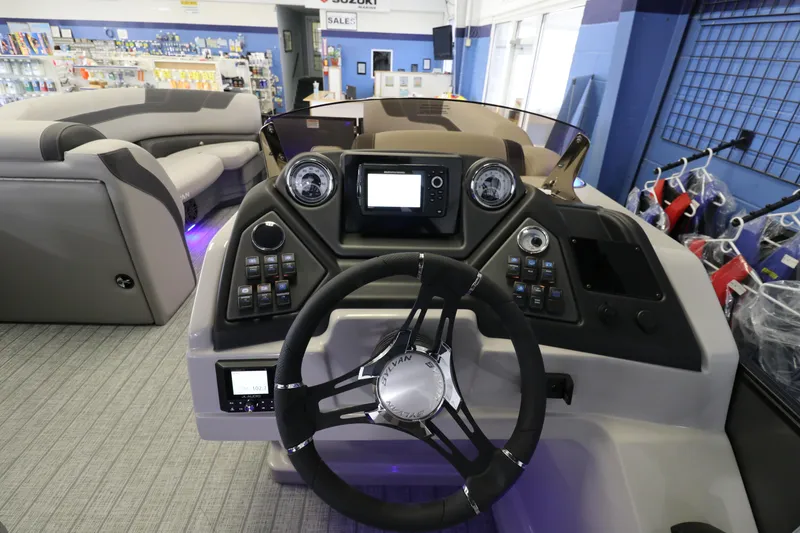 Slide: The Image of 2023 Sylvan L5 CLZ boat dashboard with modern controls and steering wheel in showroom. - 10
