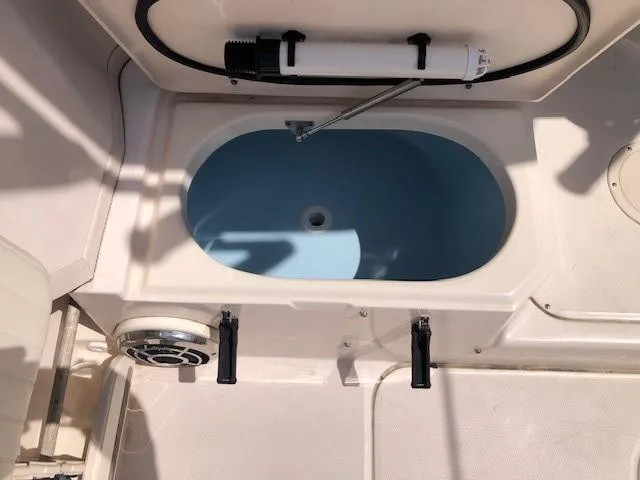 Slide: The Image of Livewell compartment on 2014 Grady-White Journey 258 boat, featuring a blue interior. - 11