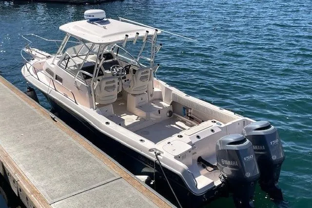 Slide: The Image of 2014 Grady-White Journey 258 boat docked, featuring dual Yamaha 150 engines. - 20