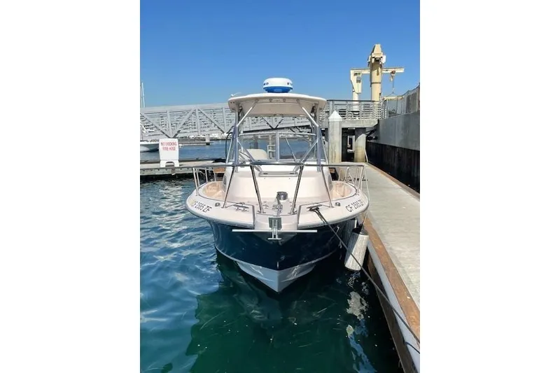 Slide: The Image of 2014 Grady-White Journey 258 boat docked at marina under clear blue sky. - 3