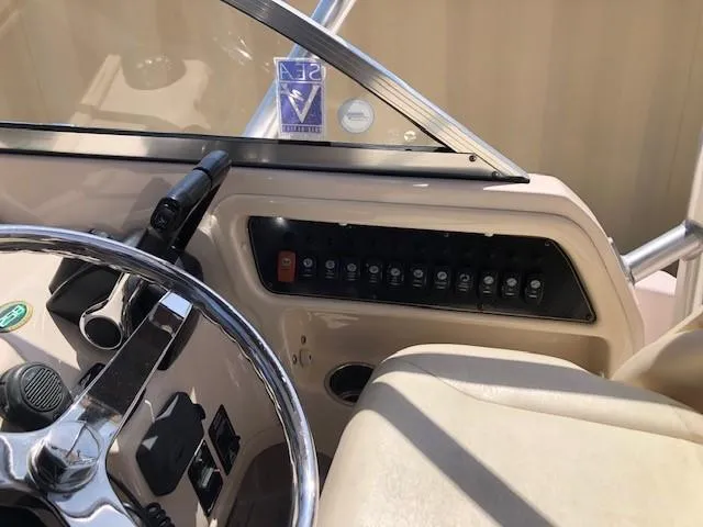 Slide: The Image of 2014 Grady-White Journey 258 boat dashboard with steering wheel and control panel. - 8