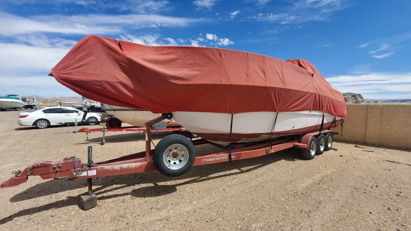 Slide: The Image of 1997 Chaparral Signature 29 boat covered on a trailer in a parking lot. - 15