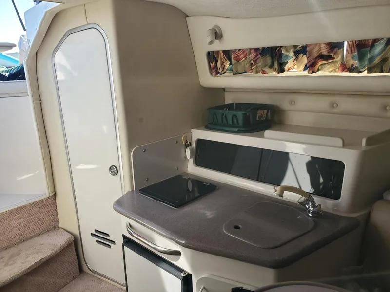 Slide: The Image of 1997 Chaparral Signature 29 boat interior kitchen with sink, stove, and storage. - 9