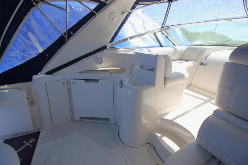 Slide: The Image of 2000 Cruisers Yachts 3870 Express interior with white seating and helm station. - 10