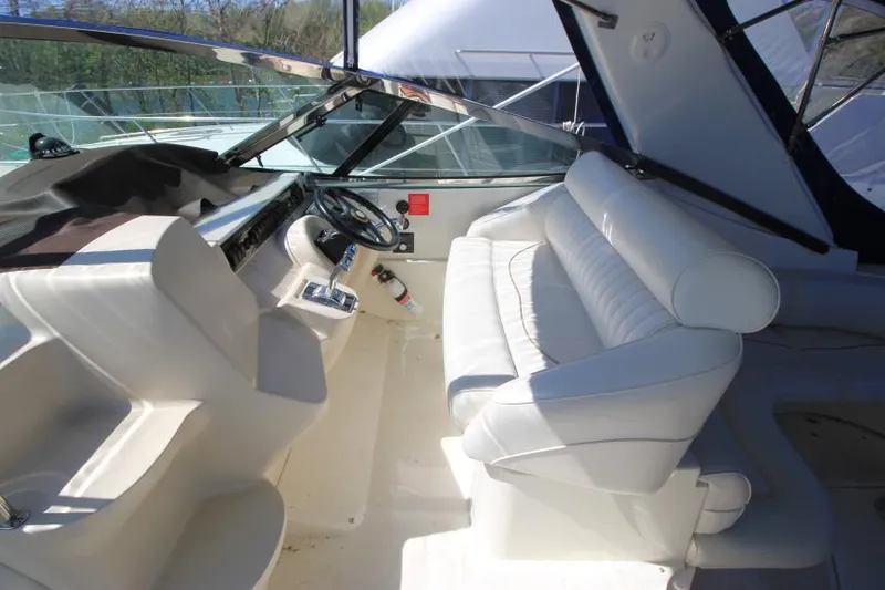 Slide: The Image of 2000 Cruisers Yachts 3870 Express cockpit with white seating and steering wheel. - 15