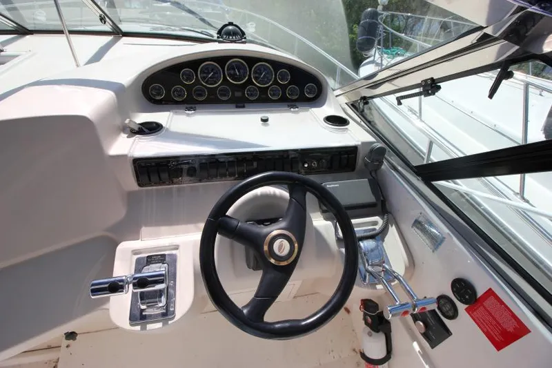 Slide: The Image of Cockpit of 2000 Cruisers Yachts 3870 Express, featuring steering wheel and control panel. - 16