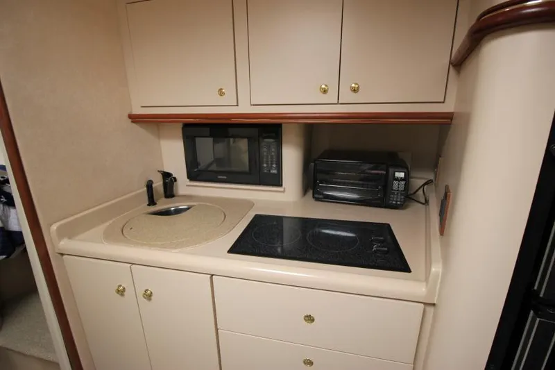 Slide: The Image of 2000 Cruisers Yachts 3870 Express kitchen with stove, microwave, and sink. - 20