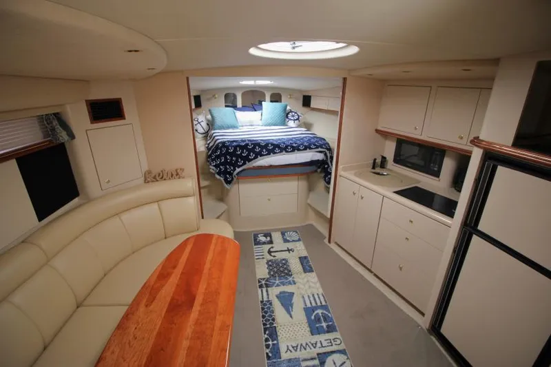 Slide: The Image of Interior of 2000 Cruisers Yachts 3870 Express, featuring cozy seating and compact kitchen. - 27