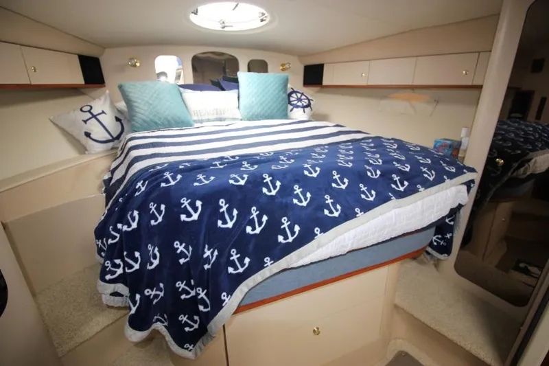 Slide: The Image of Cozy cabin interior of 2000 Cruisers Yachts 3870 Express with nautical-themed bedding. - 28