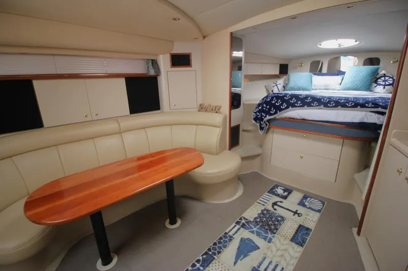 Slide: The Image of 2000 Cruisers Yachts 3870 Express interior with cozy seating and nautical-themed decor. - 29
