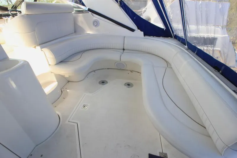 Slide: The Image of 2000 Cruisers Yachts 3870 Express interior with white seating and blue accents. - 9