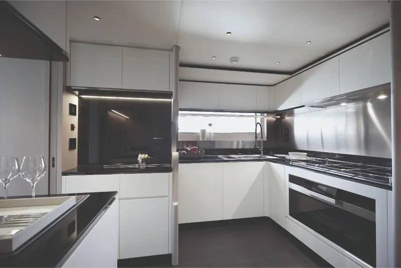 Slide: The Image of Modern kitchen interior on 2023 Azimut Trideck yacht with sleek white cabinetry and black countertops. - 39