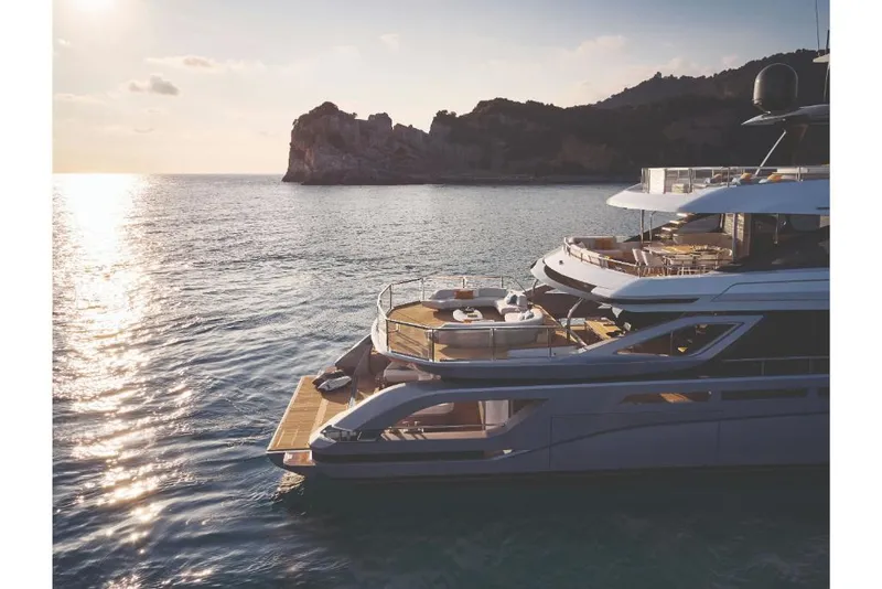 Slide: The Image of 2023 Azimut Trideck yacht cruising near a scenic coastline at sunset. - 6