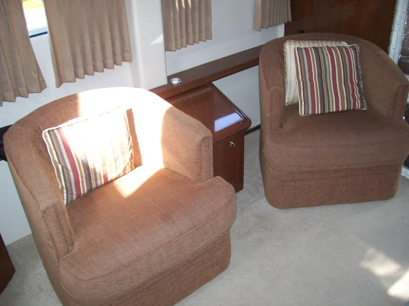 Slide: The Image of Interior of 2007 Carver 43 Motor Yacht with two brown armchairs and striped cushions. - 17