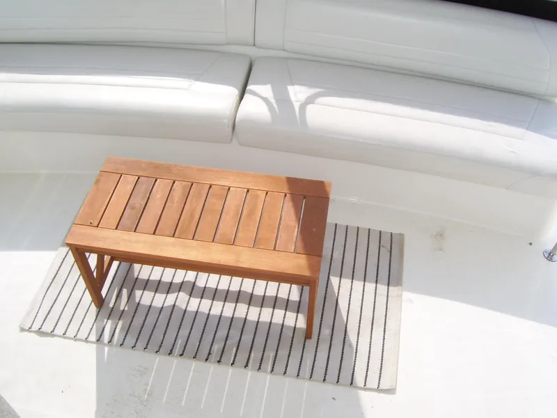 Slide: The Image of 2007 Carver 43 Motor Yacht interior with white seating and wooden table on striped rug. - 2