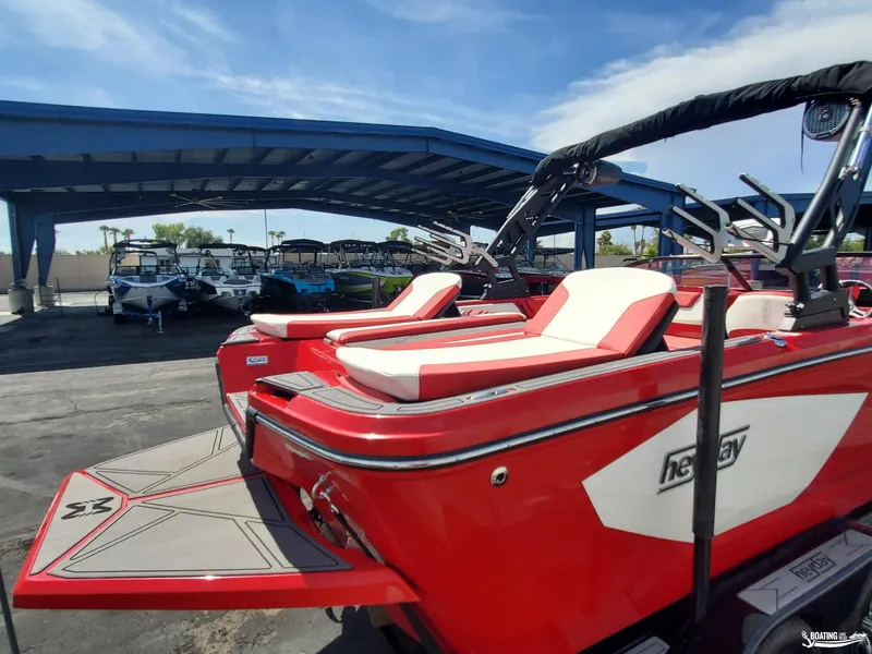 Slide: The Image of Red 2022 Heyday WT-2DC boat displayed under a blue canopy at a dealership. - 13