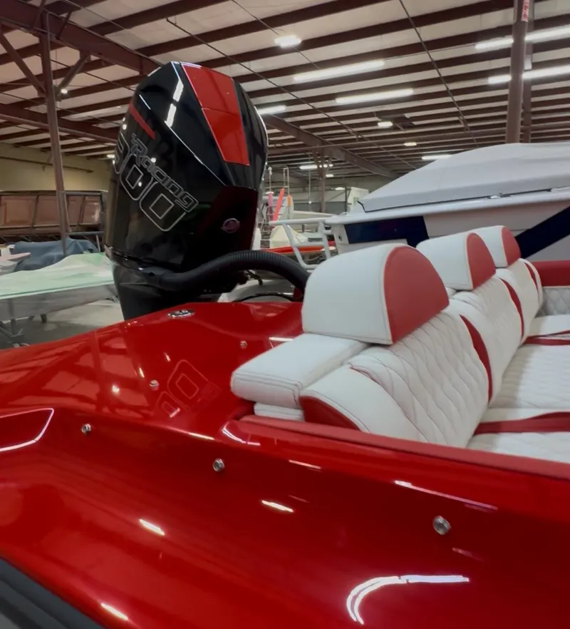 Slide: The Image of Red and white Velocity 22 Punisher boat, 2026 model, with powerful outboard motor in a showroom. - 11