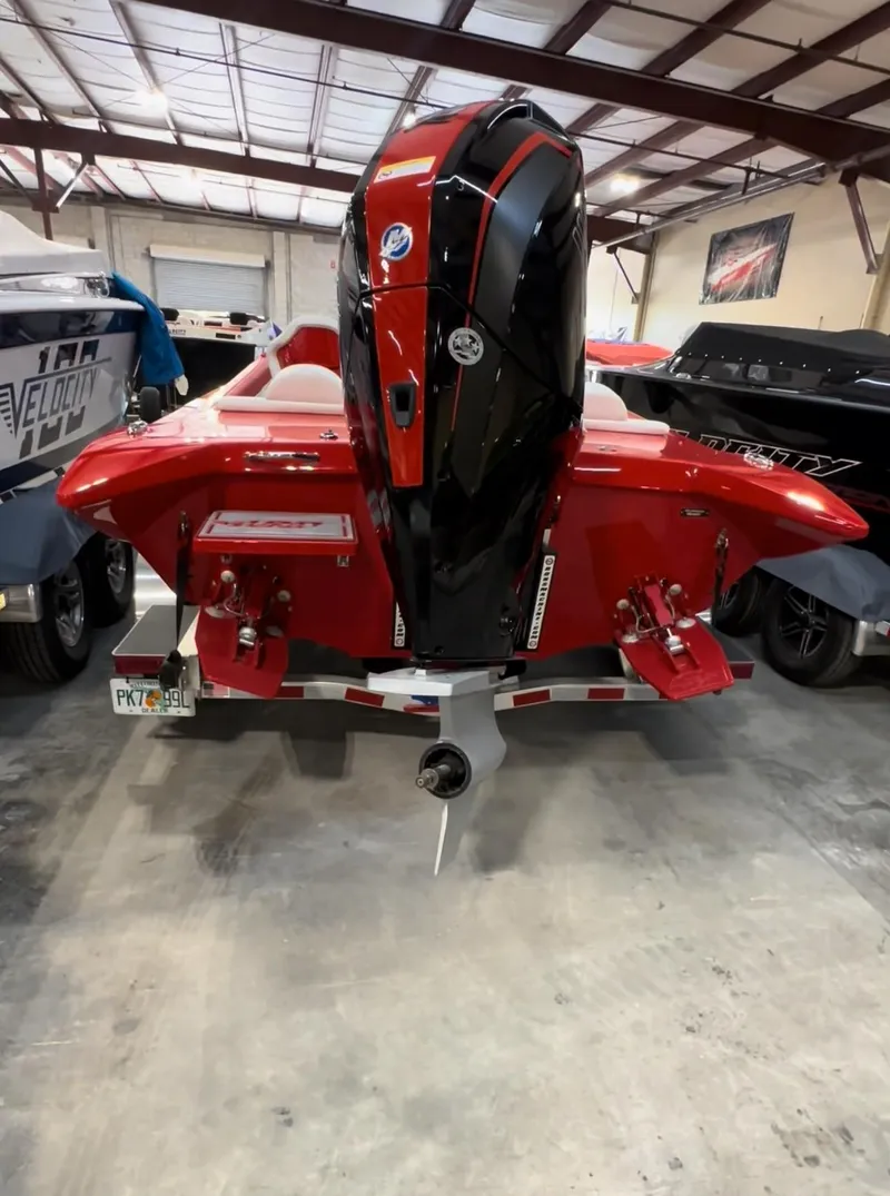 Slide: The Image of Red 2026 Velocity 22 Punisher boat with powerful outboard motor in a garage setting. - 14