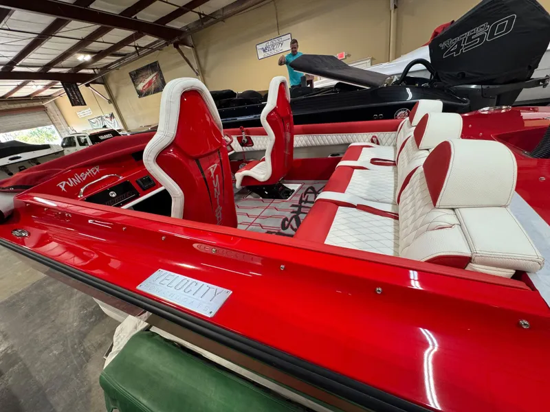 Slide: The Image of Red Velocity 22 Punisher boat, 2026 model, with white and red interior seating. - 2